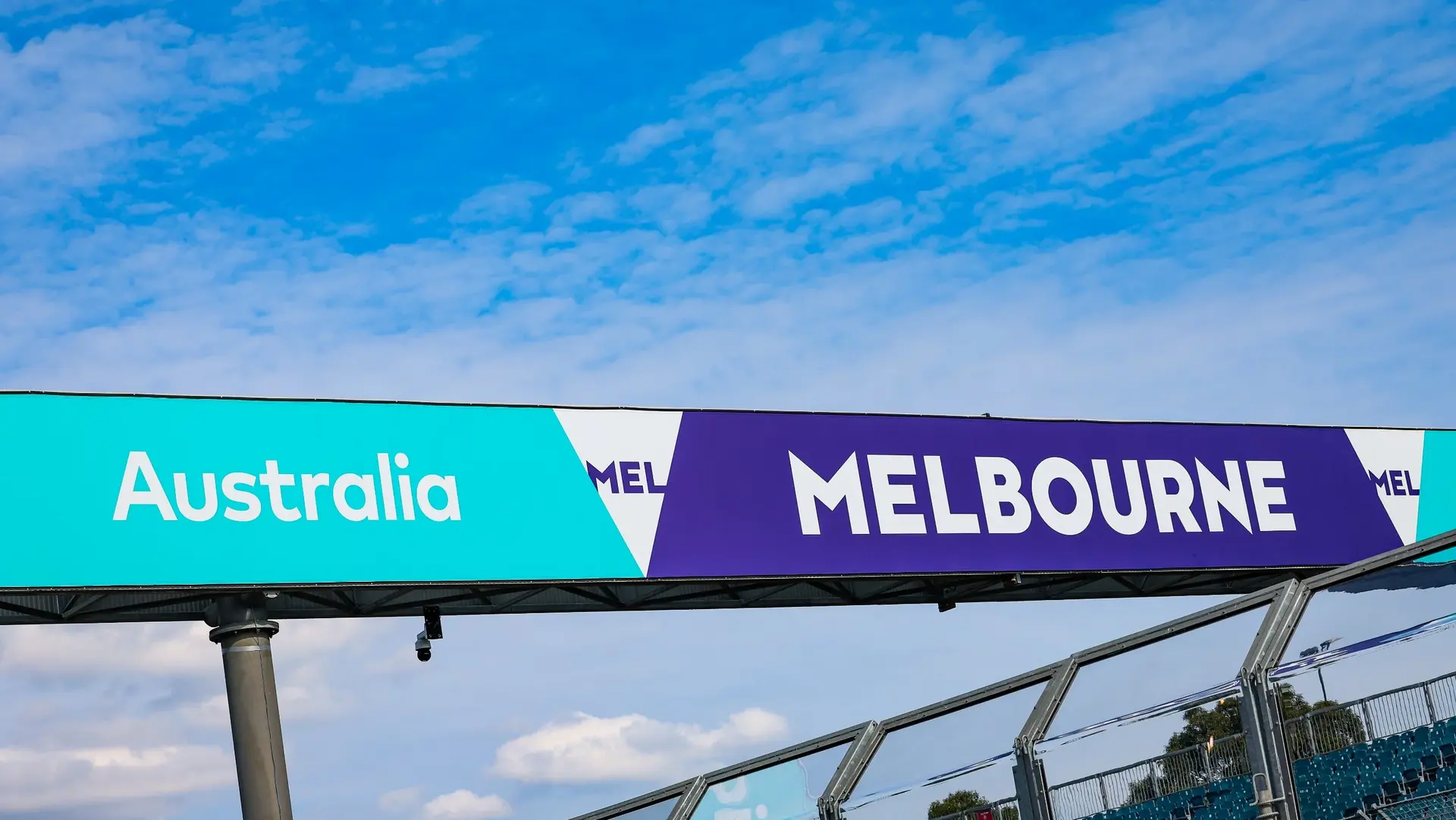 Melbourne Grand Prix Circuit sign at Albert Park, showcasing the official branding for the Australian Grand Prix 2025 under a blue sky with scattered clouds.