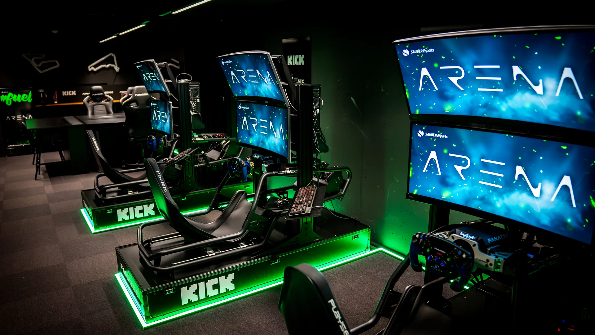 Esports gaming arena with multiple illuminated gaming stations and large display screens.