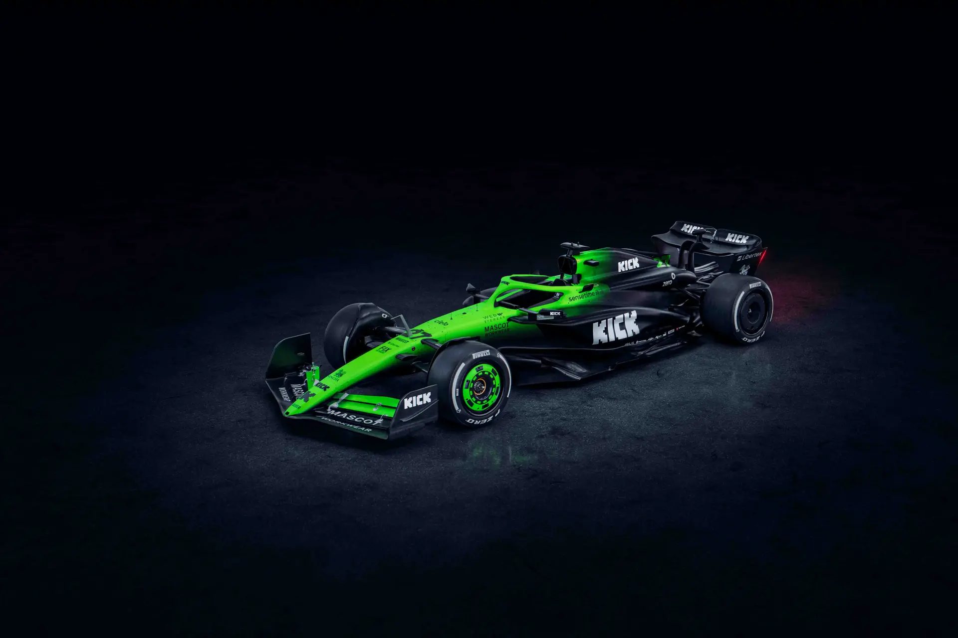 Three-quarter front view of the Sauber C45 Formula 1 car, illuminated in a dark setting, highlighting its aerodynamic design and vibrant green and black livery.