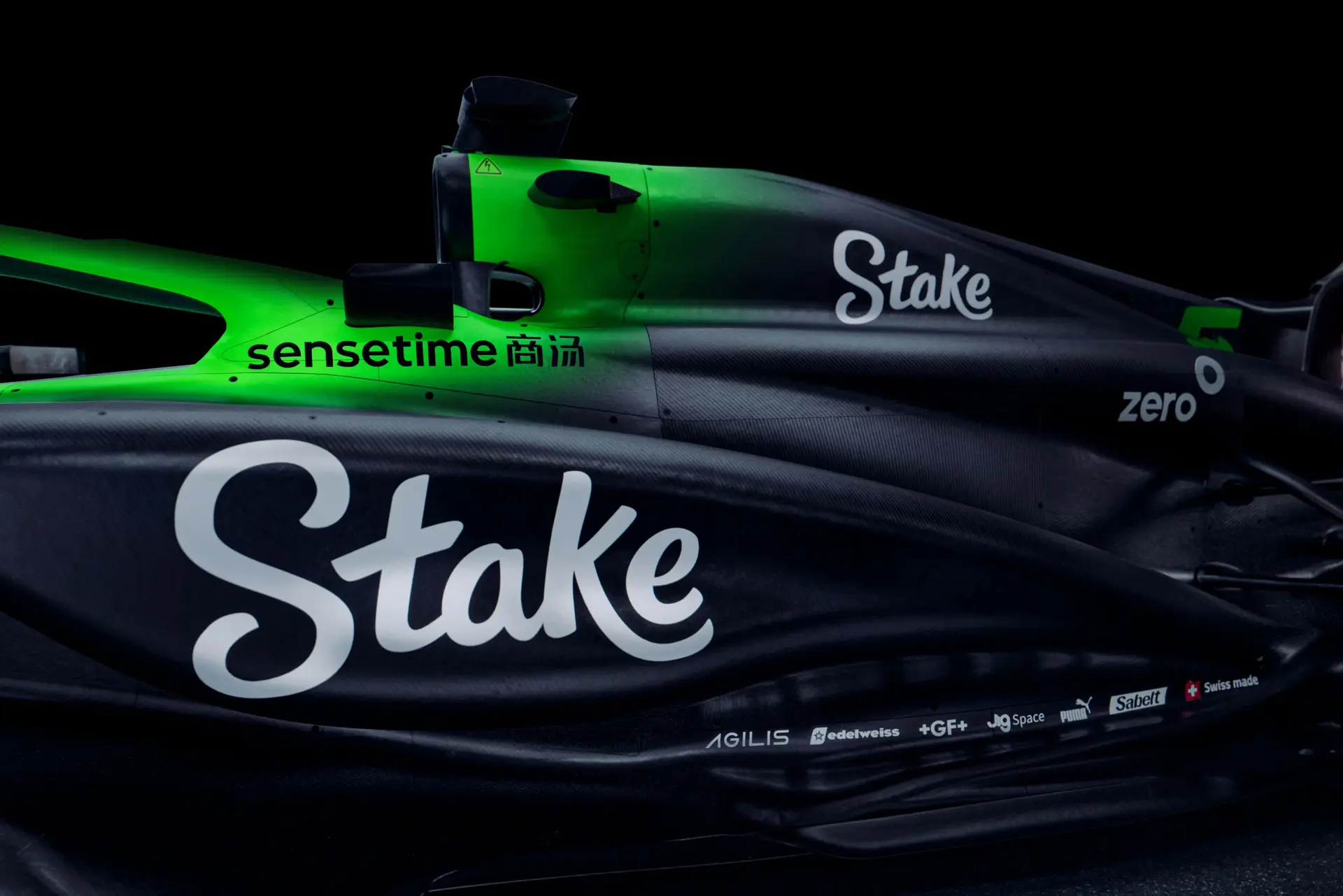 Close-up of the right side of the Sauber C45 Formula 1 car, highlighting the Stake branding, aerodynamic bodywork, and green accent lighting.