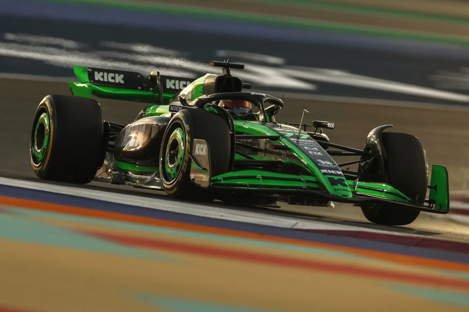 A Sauber F1 car speeding on the track during the 2024 Qatar Grand Prix free practice session, with motion blur and track lights illuminating the scene.