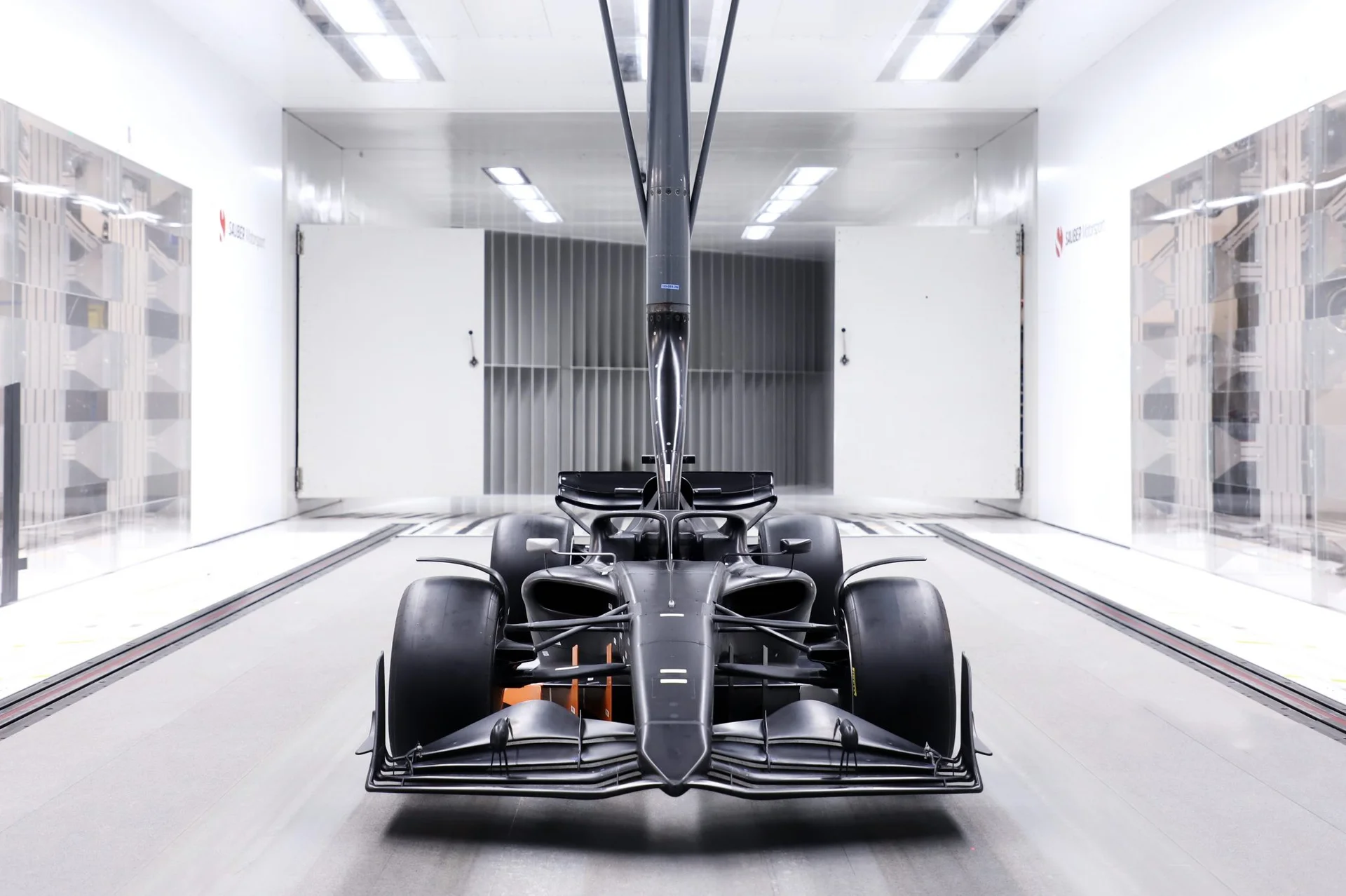 A Formula 1 car inside a modern wind tunnel, capturing airflow dynamics and aerodynamic testing.