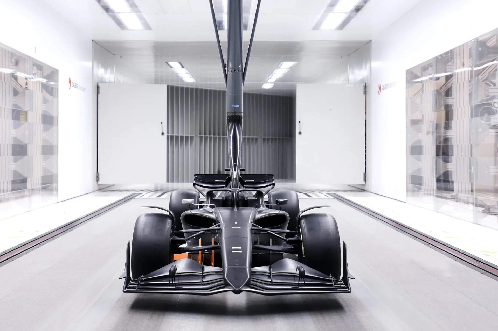 A Formula 1 car inside a modern wind tunnel, capturing airflow dynamics and aerodynamic testing.
