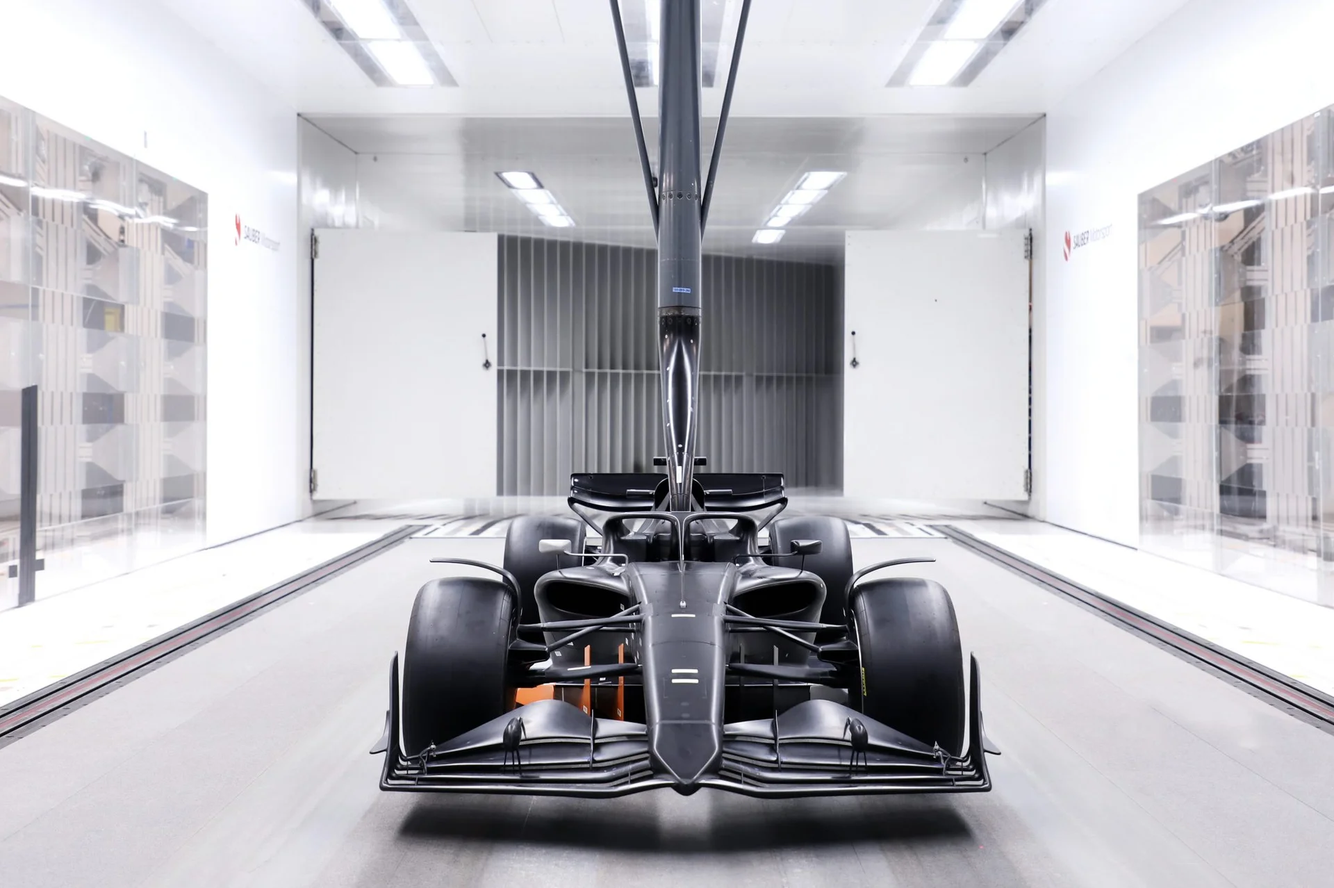 A Formula 1 car inside a modern wind tunnel, capturing airflow dynamics and aerodynamic testing.