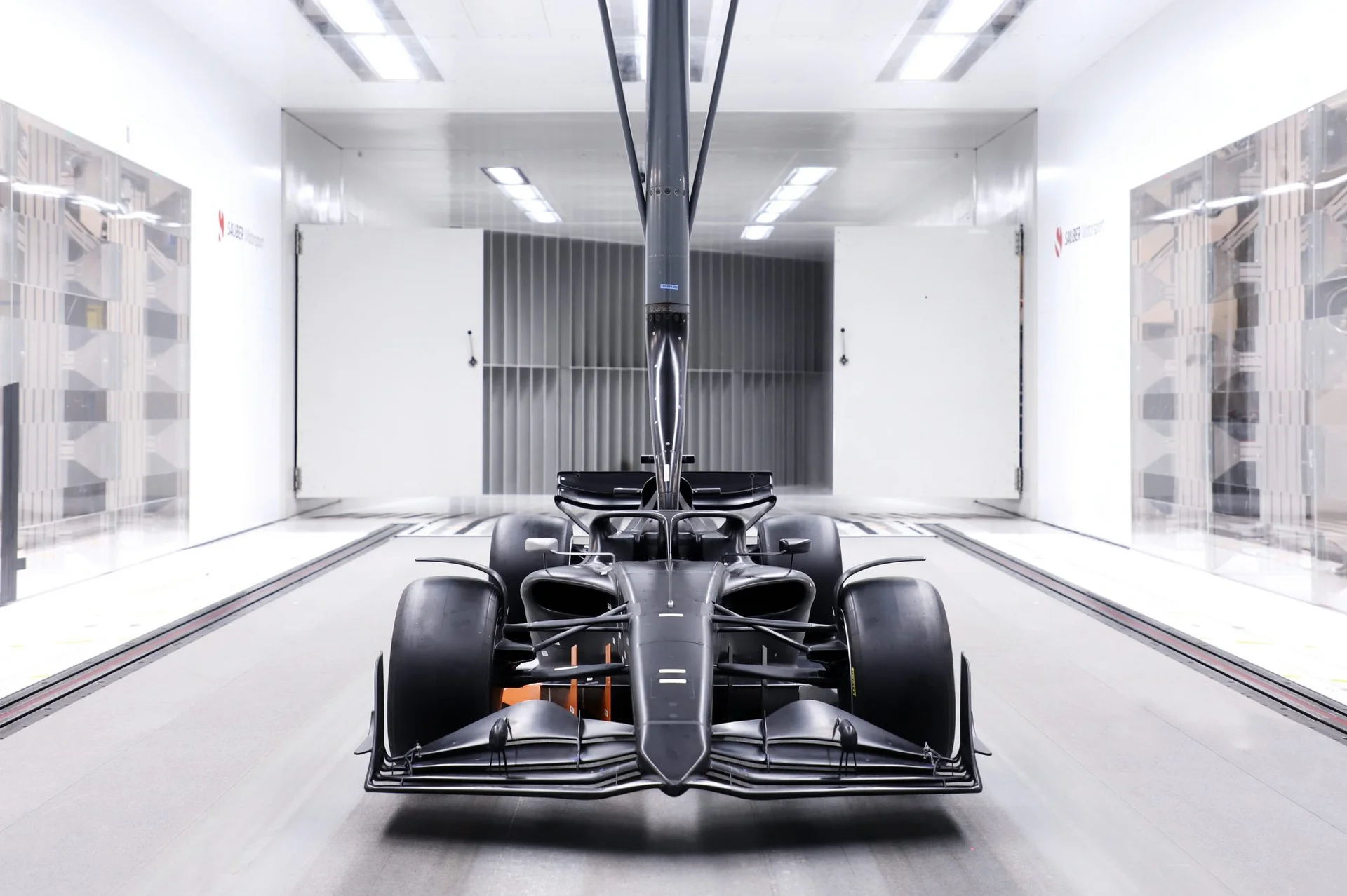 A Formula 1 car inside a modern wind tunnel, capturing airflow dynamics and aerodynamic testing.