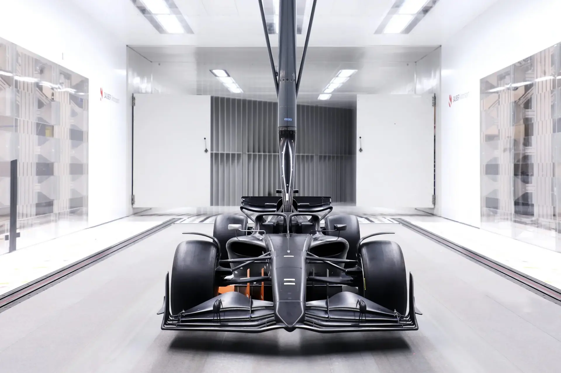 A Formula 1 car inside a modern wind tunnel, capturing airflow dynamics and aerodynamic testing.