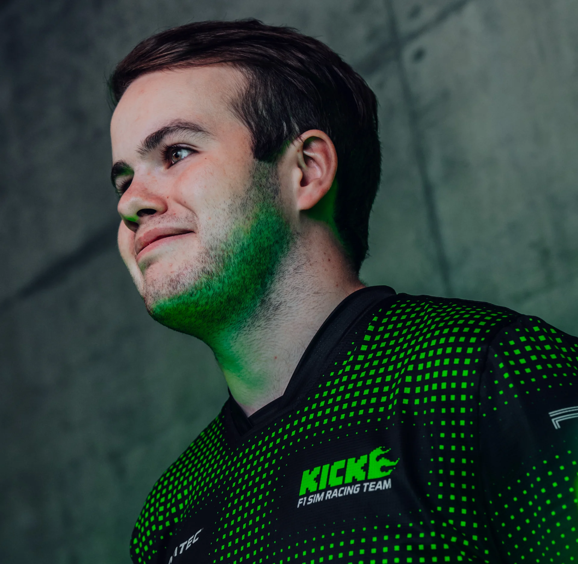 Thomas Ronhaar, Sauber Motorsport Esports driver, in a neon-lit gaming environment, wearing a racing team jersey.