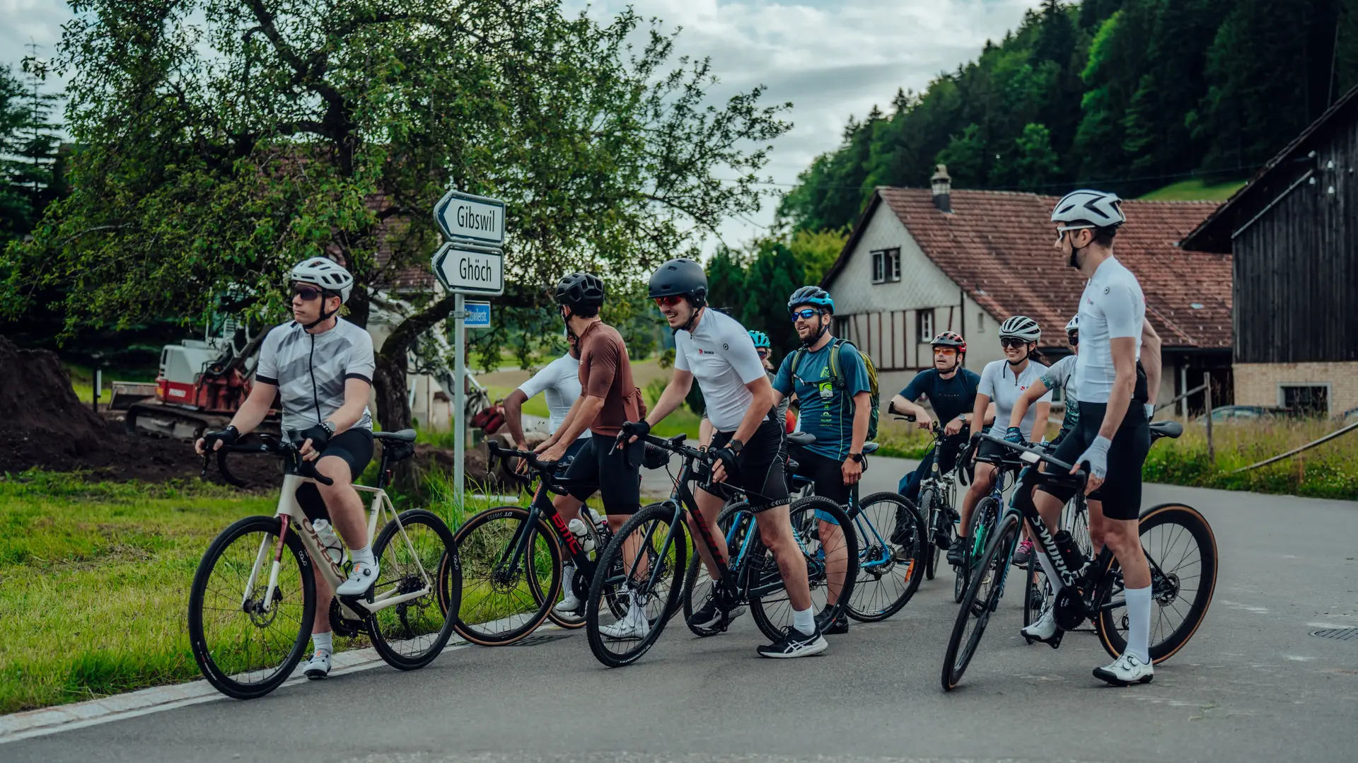 Group of Sauber Motorsport employees and cycling enthusiasts gathered for an industrial building for an afterwork cycling event.