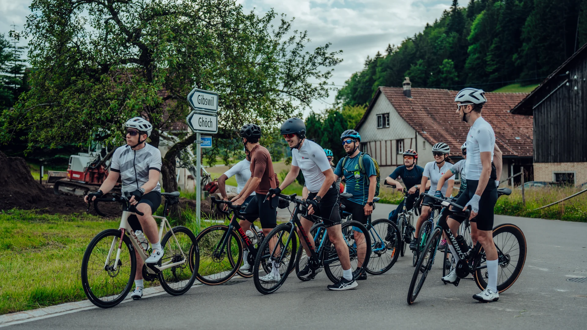 Group of Sauber Motorsport employees and cycling enthusiasts gathered for an industrial building for an afterwork cycling event.