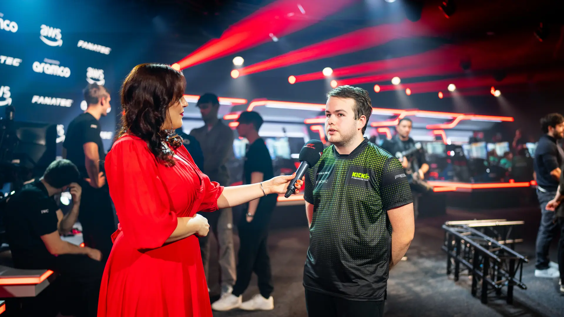 Thomas Ronhaar, Sauber Motorsport Esports driver, receiving recognition at an F1 sim racing event, engaging in a conversation on stage.