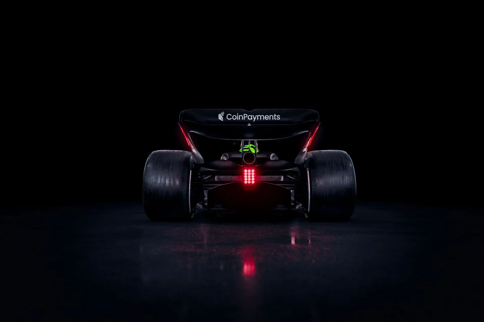 Rear view of the Sauber C45 Formula 1 car, featuring Stake branding and illuminated rear lights against a dark background.