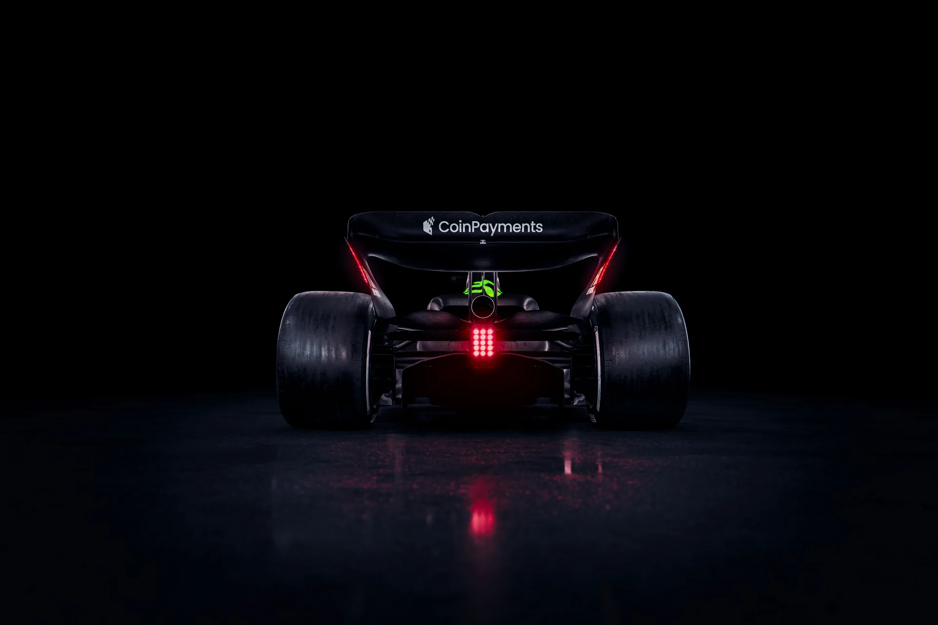 Rear view of the Sauber C45 Formula 1 car, featuring Stake branding and illuminated rear lights against a dark background.
