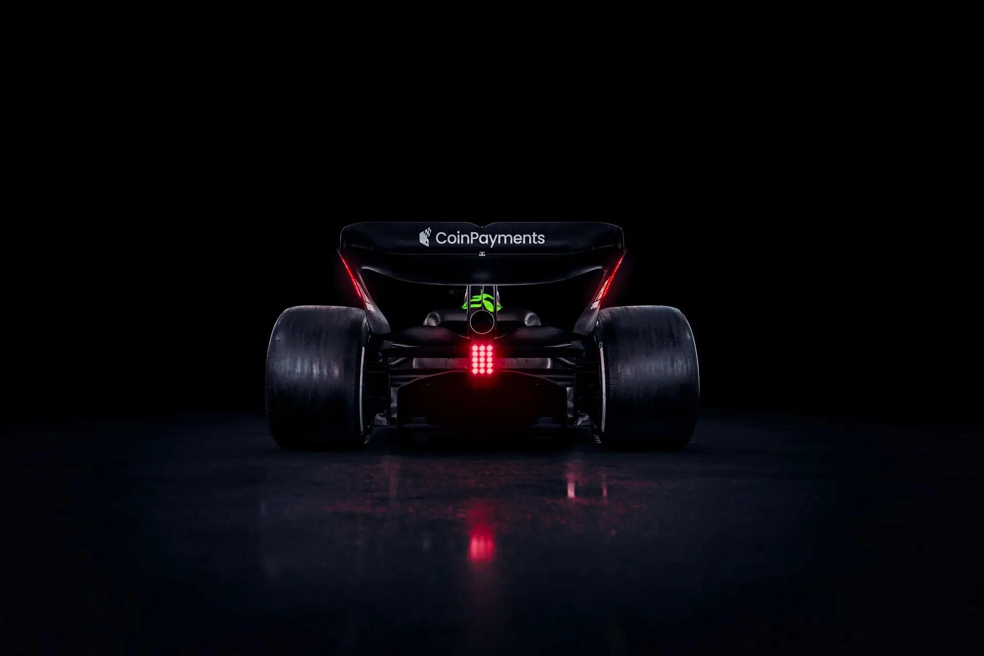 Rear view of the Sauber C45 Formula 1 car, featuring Stake branding and illuminated rear lights against a dark background.