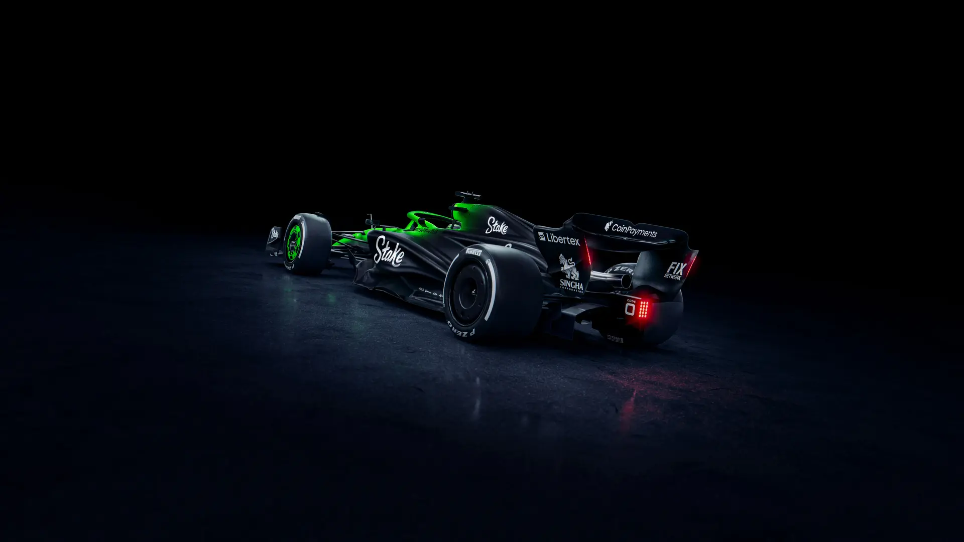 Rear three-quarter view of the Sauber C45 Formula 1 car, highlighting the Stake sponsorship and intricate aerodynamic design. The illuminated green and black livery contrasts against a dark background, showcasing the rear wing and diffuser.