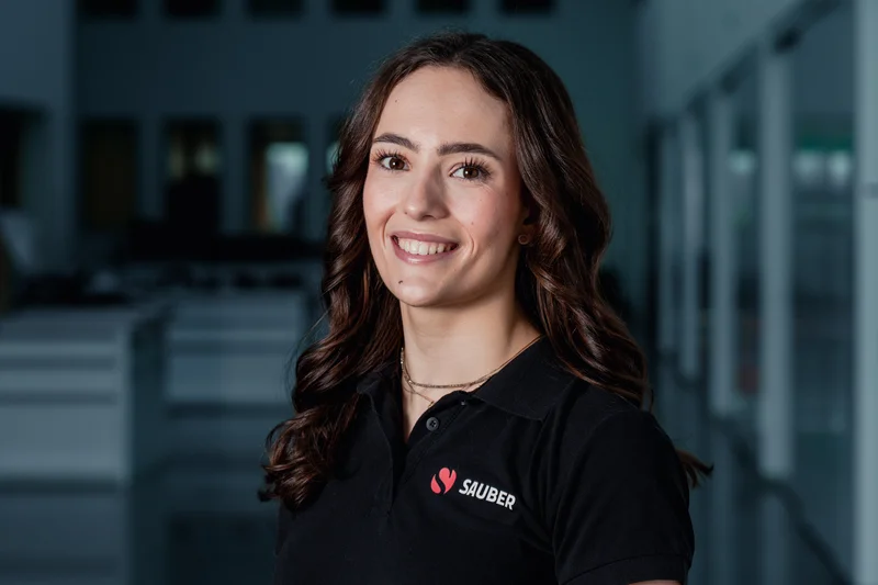 Emma Felbermayr, F1 Academy driver for Sauber, smiling in team apparel during a portrait session.