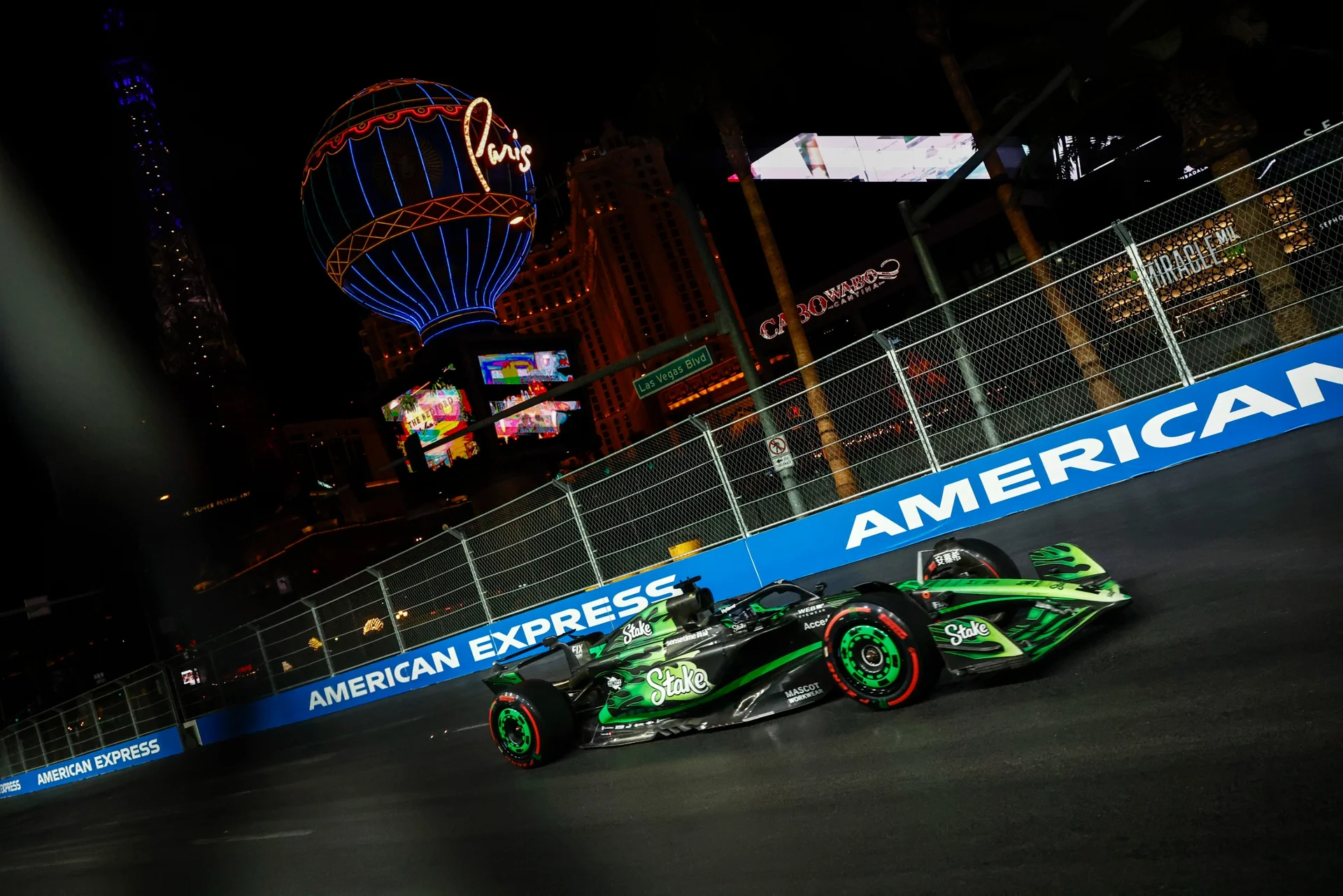 A high-resolution image (4000x3000) of the C44 Formula 1 car, showcasing its rear left view with a dynamic fire trail effect and Stake branding during a twilight race scene.