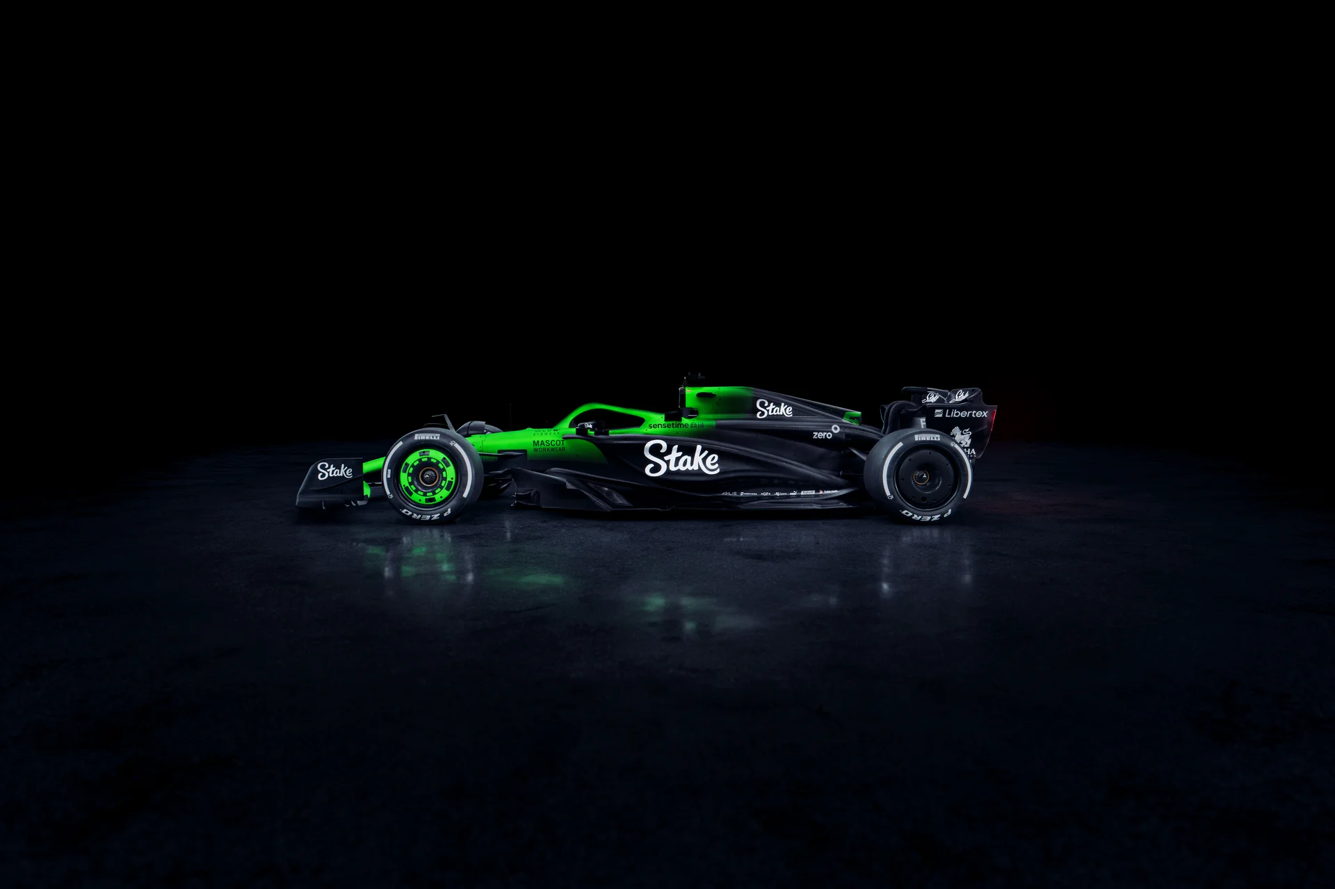 Side view of the Sauber C45 Formula 1 car from the left, featuring Stake branding and illuminated aerodynamic details against a dark background.