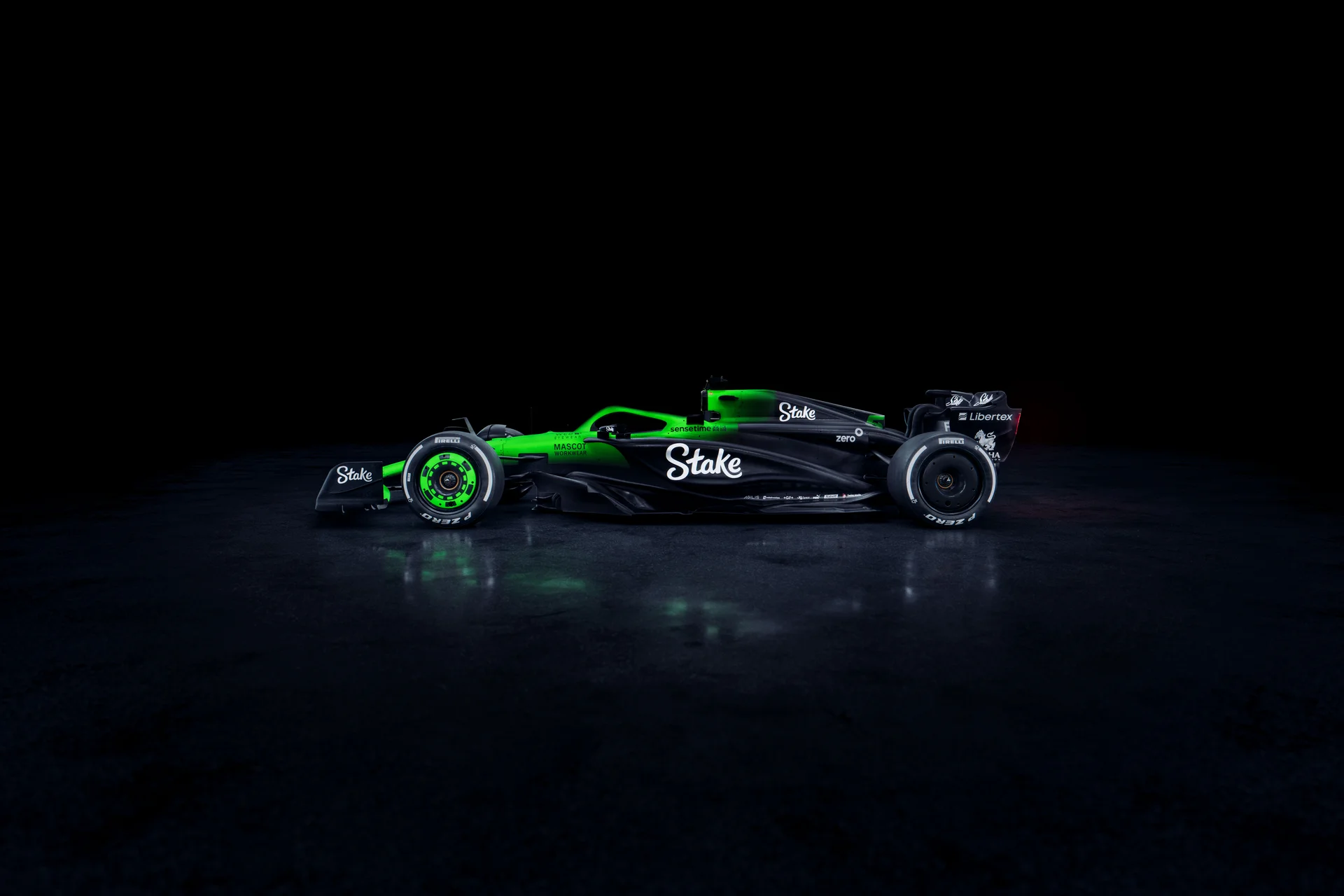 Side view of the Sauber C45 Formula 1 car from the left, featuring Stake branding and illuminated aerodynamic details against a dark background.
