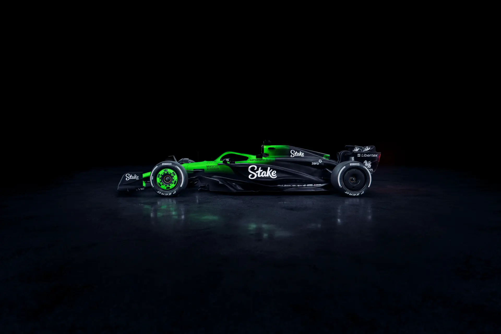 Side view of the Sauber C45 Formula 1 car from the left, featuring Stake branding and illuminated aerodynamic details against a dark background.
