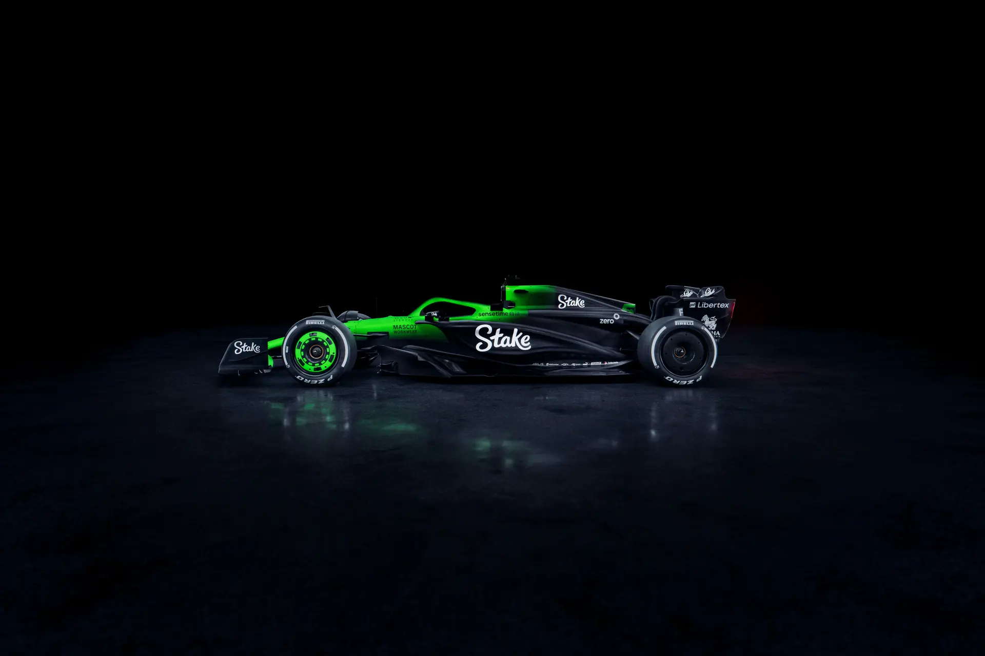 Side view of the Sauber C45 Formula 1 car from the left, featuring Stake branding and illuminated aerodynamic details against a dark background.