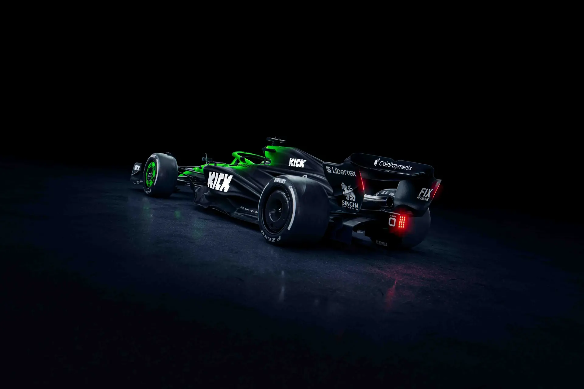 Three-quarter rear view of the Sauber C45 Formula 1 car, illuminated in a dark setting, highlighting its aerodynamic rear wing, diffuser, and sponsor branding.