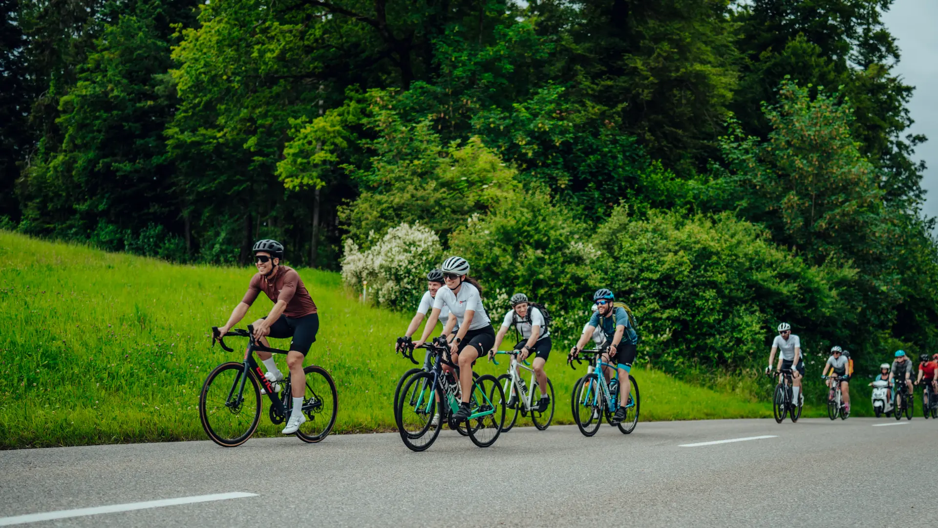 Group of Sauber Motorsport employees and cycling enthusiasts gathered for an industrial building for an afterwork cycling event.