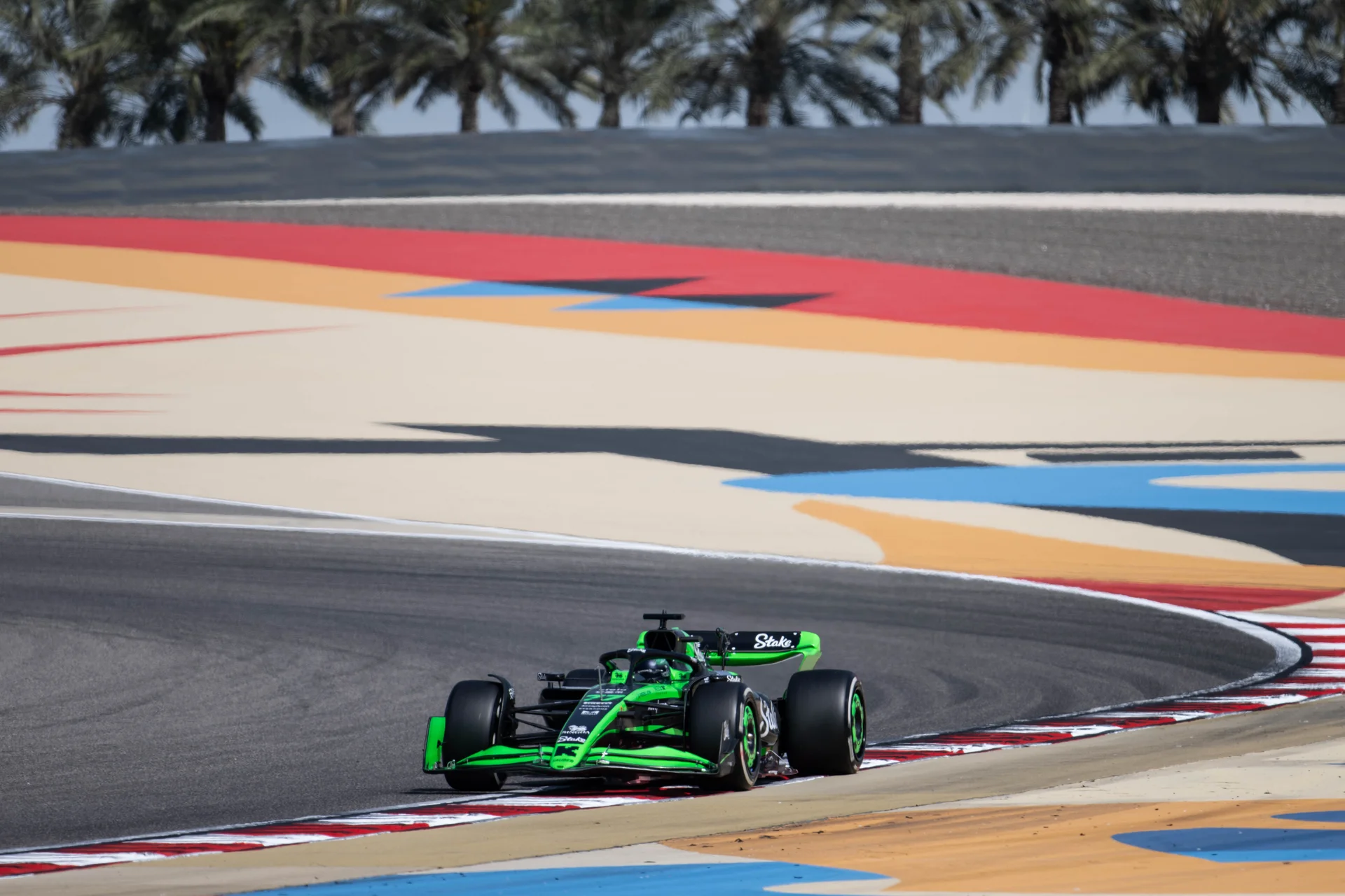 A green Formula 1 car on track during a pre-season testing session at the Bahrain Grand Prix.