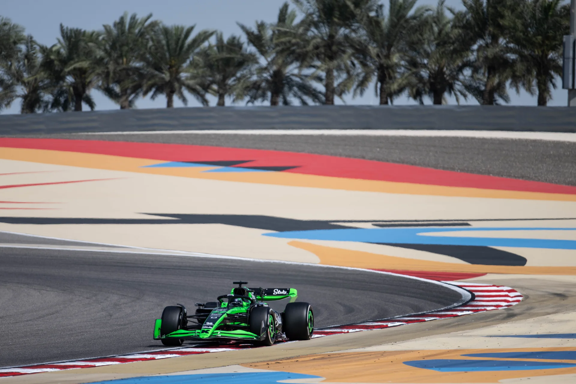 A green Formula 1 car on track during a pre-season testing session at the Bahrain Grand Prix.