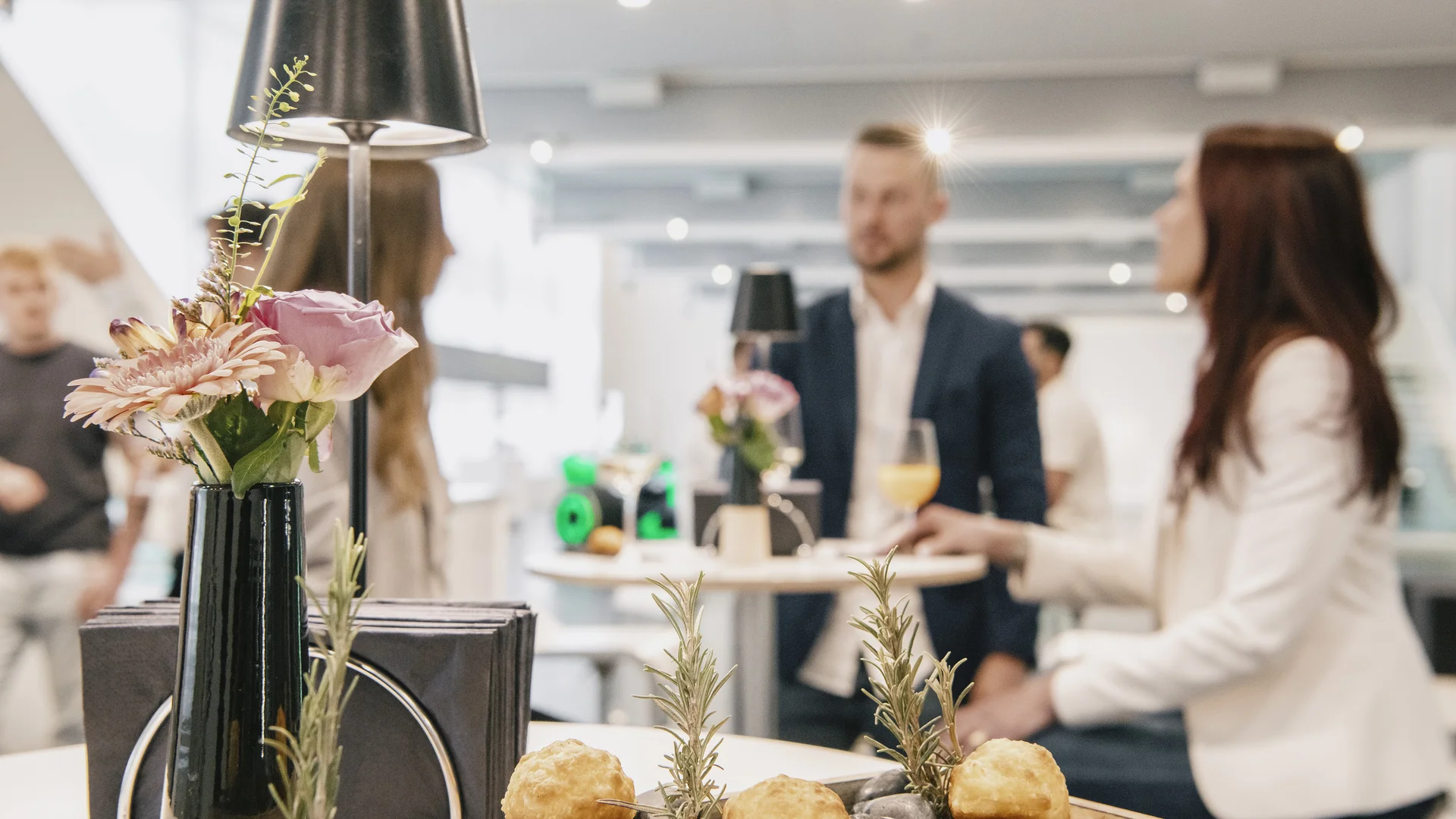 Guests networking and enjoying a buffet-style catering setup at a corporate event in a modern venue.