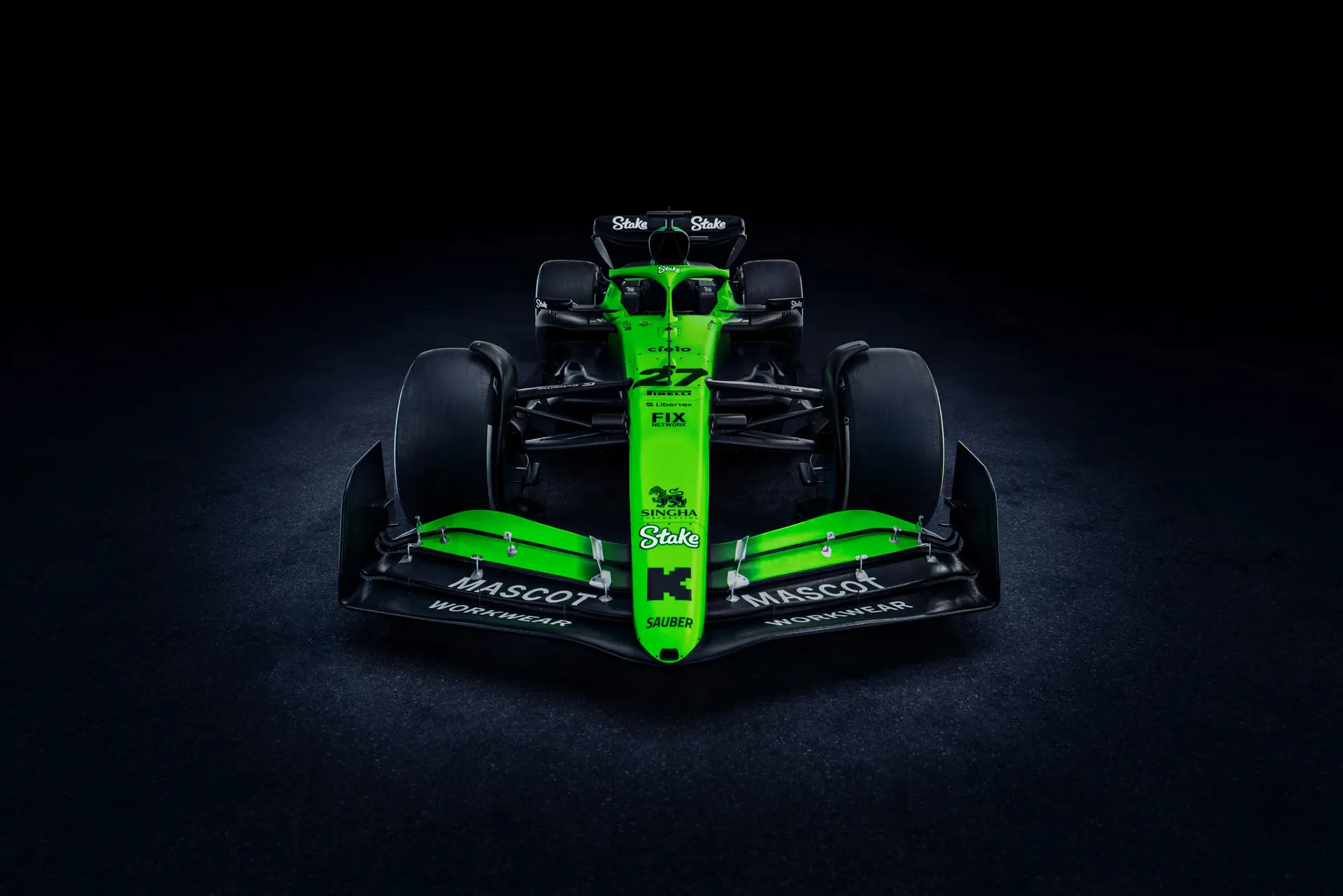 Front view of the Sauber C45 Formula 1 car, showcasing its aerodynamic front wing, Stake branding, and bright green and black livery under dramatic lighting.