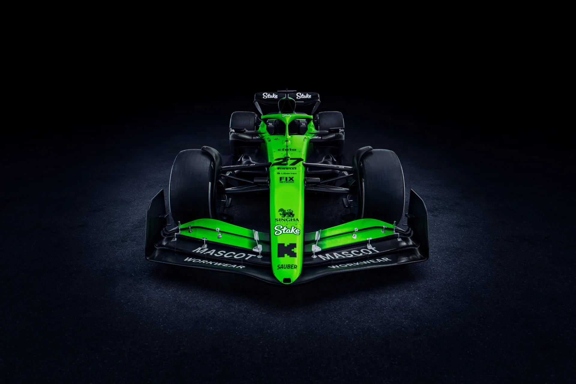 Front view of the Sauber C45 Formula 1 car, showcasing its aerodynamic front wing, Stake branding, and bright green and black livery under dramatic lighting.