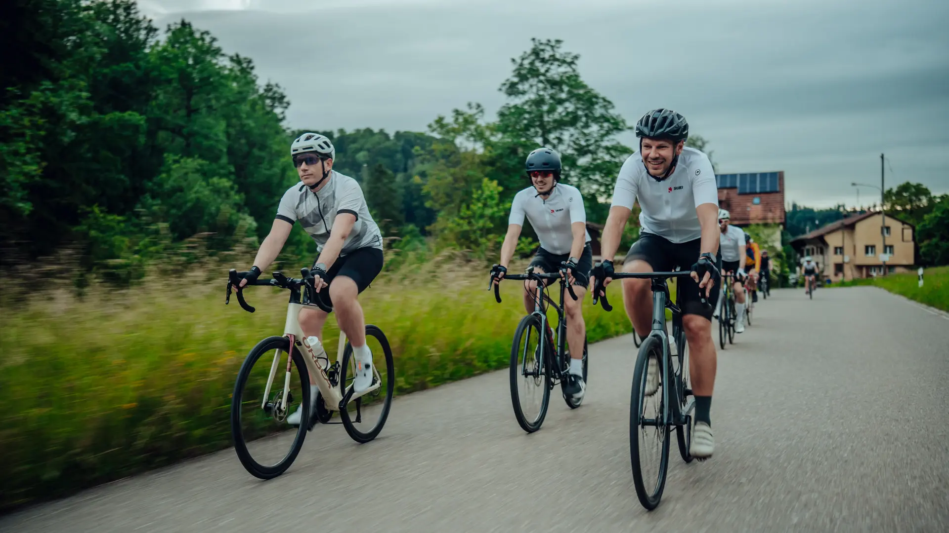 Group of Sauber Motorsport employees and cycling enthusiasts gathered for an industrial building for an afterwork cycling event.