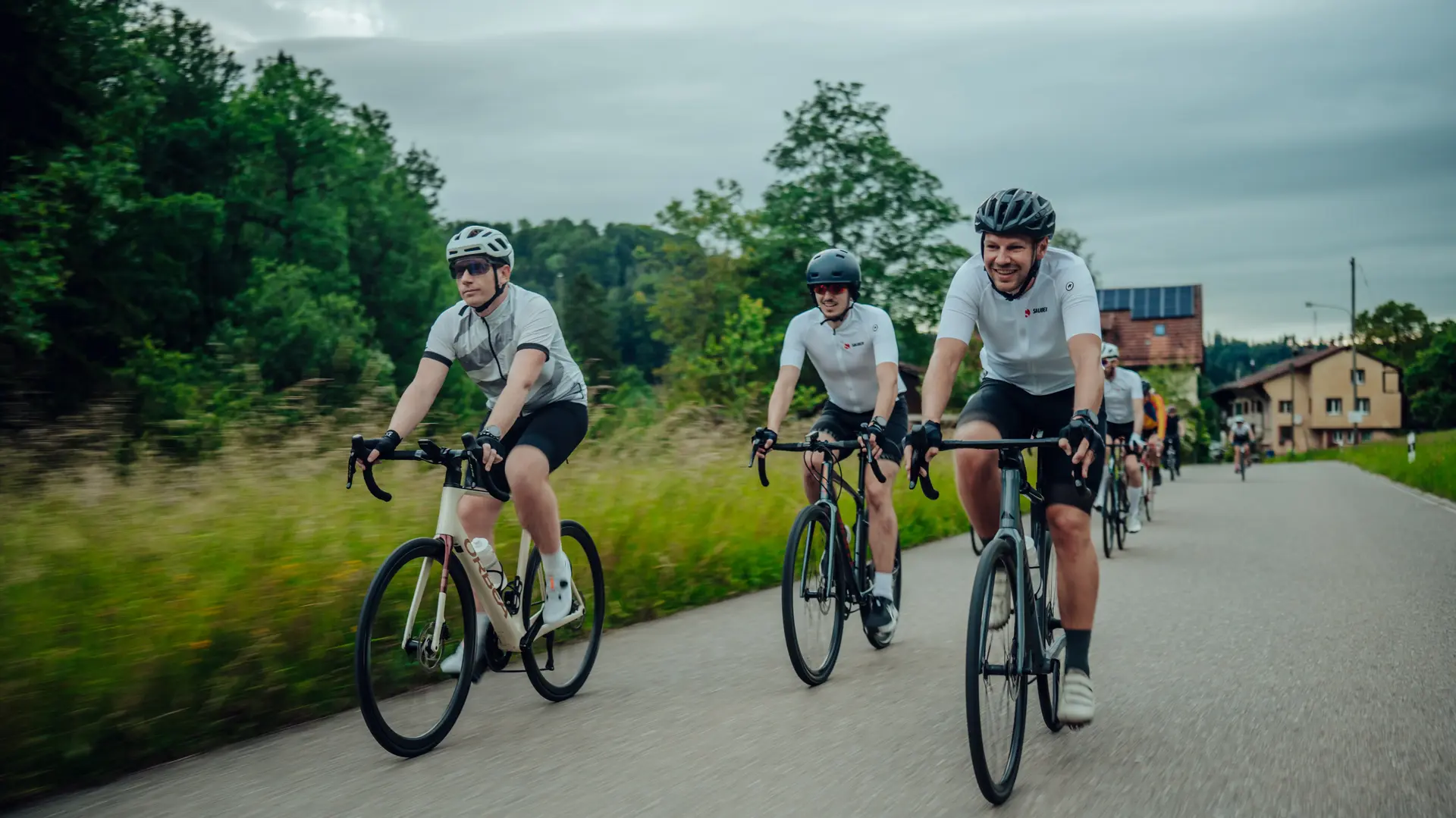 Group of Sauber Motorsport employees and cycling enthusiasts gathered for an industrial building for an afterwork cycling event.