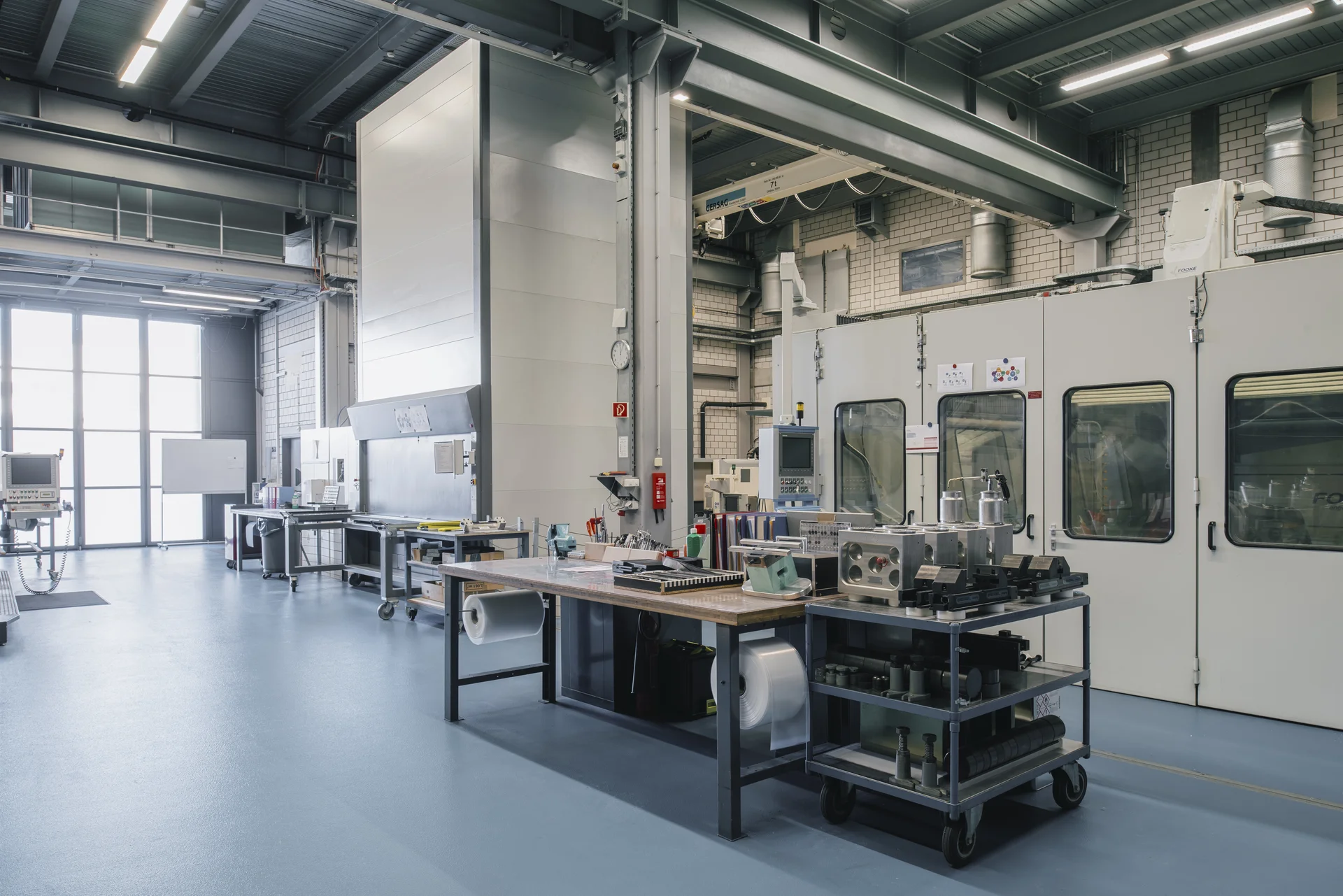 A high-tech manufacturing area inside the Sauber F1 Team facility in Hinwil, Switzerland, featuring advanced machinery and workstations for precision engineering in Formula 1 car development.