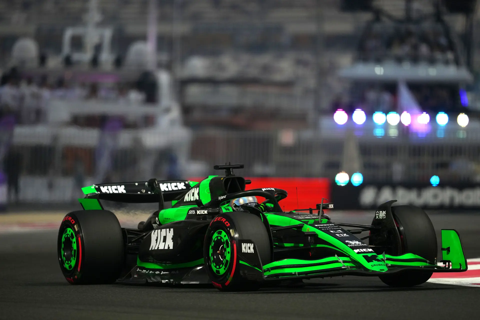A Formula 1 car speeding through the Yas Marina Circuit during the Friday practice session of the 2024 Abu Dhabi Grand Prix, illuminated by the circuit's iconic night lights.