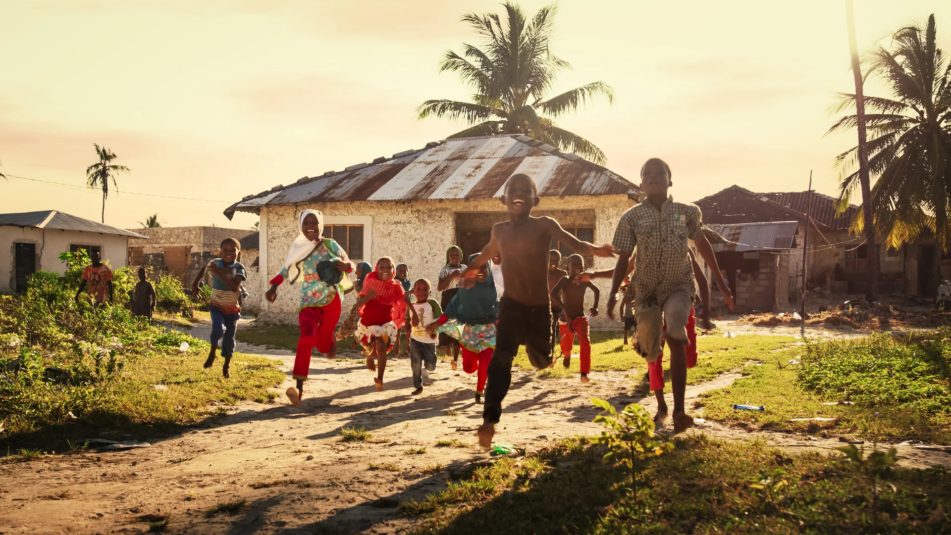 A sustainable community with people gathered around a wooden structure, surrounded by lush greenery under warm sunlight.