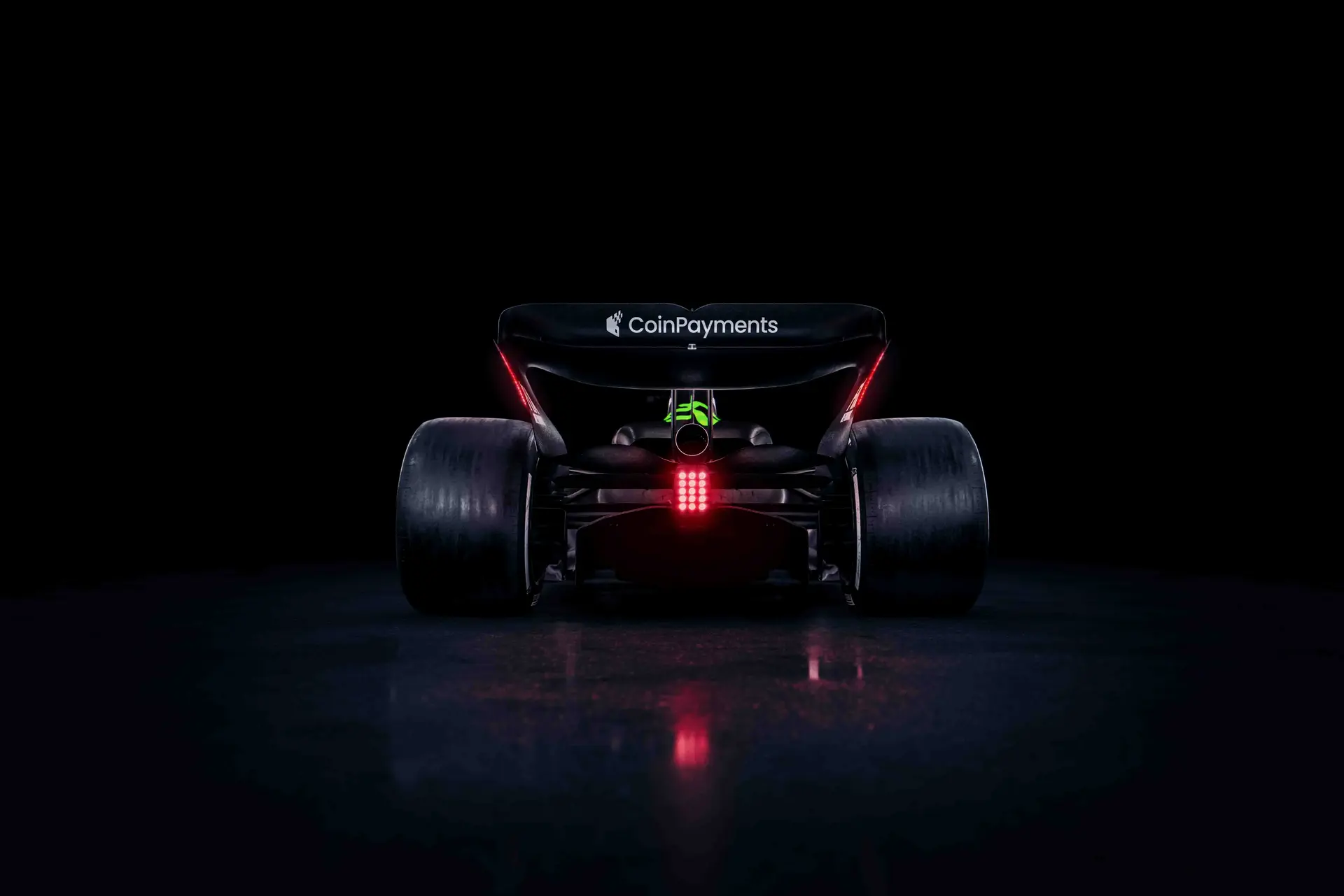 Rear view of the Sauber C45 Formula 1 car with illuminated rear lights in a dark setting, showcasing aerodynamic design and sponsor branding.