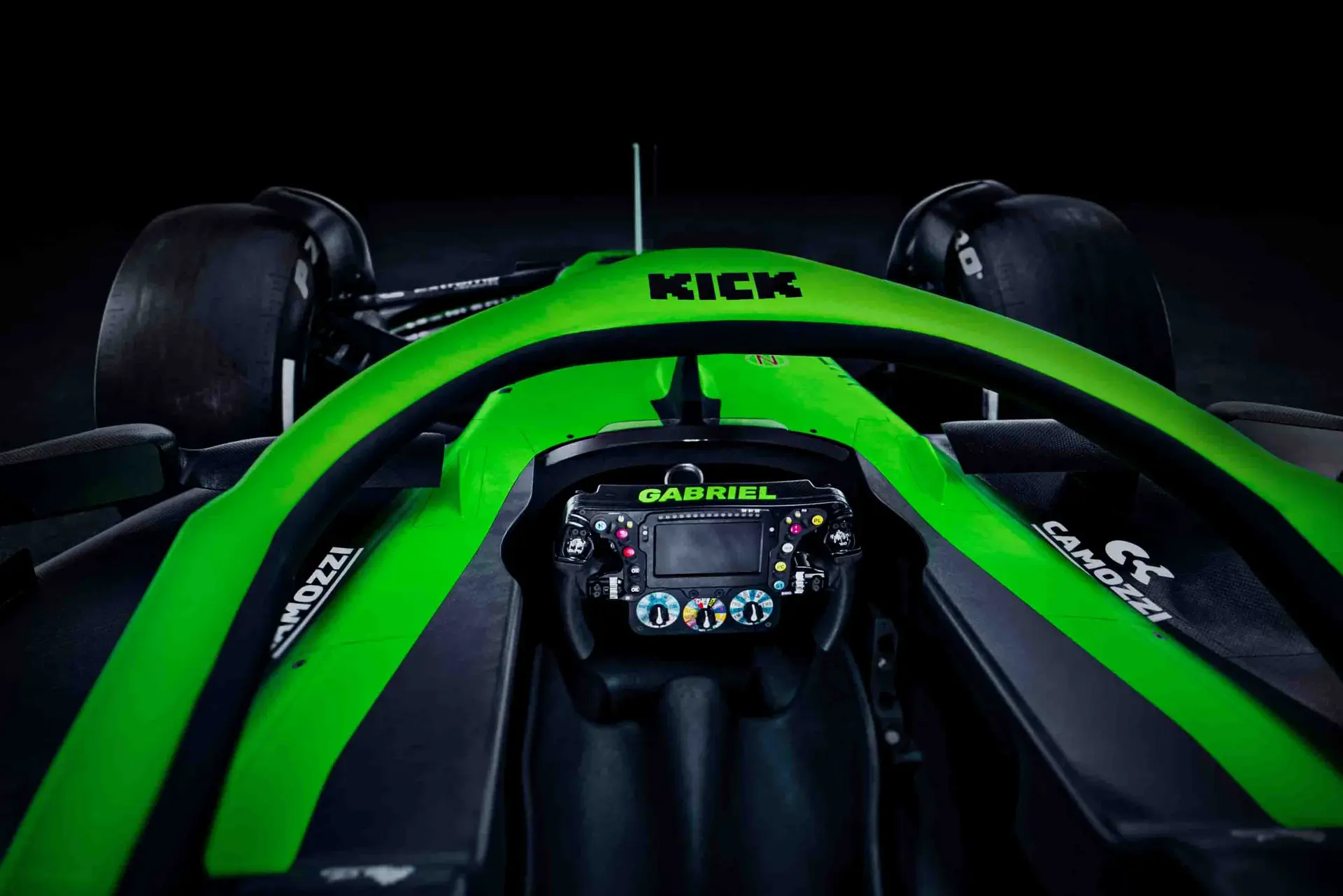 Close-up of the Halo device on the Sauber C45 Formula 1 car, featuring a bright green frame with sponsor logos and cockpit details.