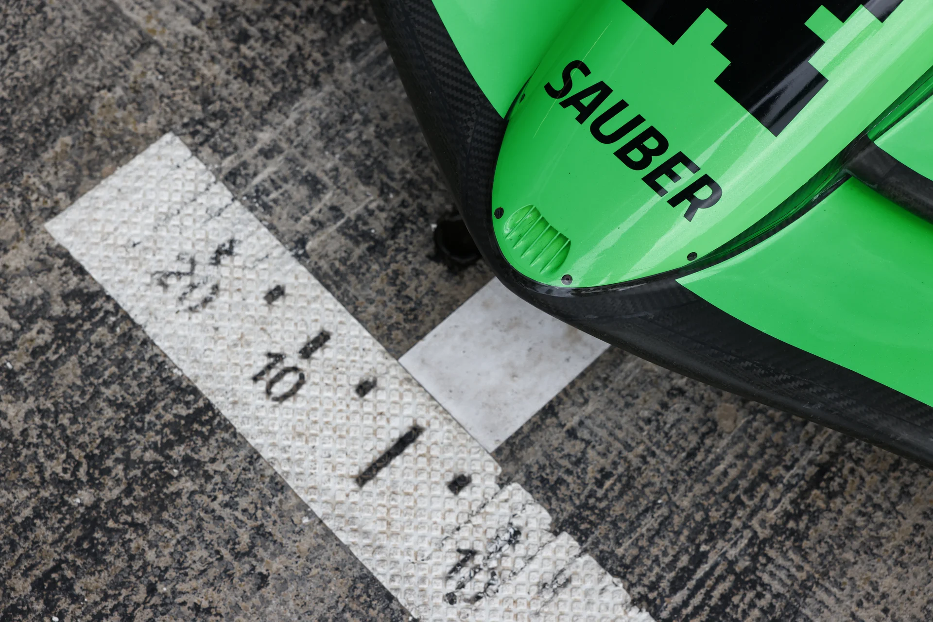 Close-up of a Sauber Formula 1 racing helmet resting on a textured surface with the date "30.10.2024" marked, symbolizing a key announcement or event for the team.