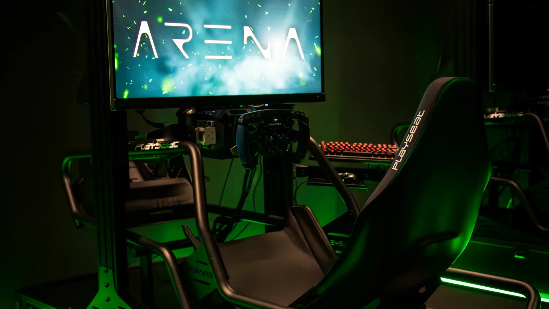 Esports gaming setup featuring dual monitors, neon green LED accents, and a racing-style chair.