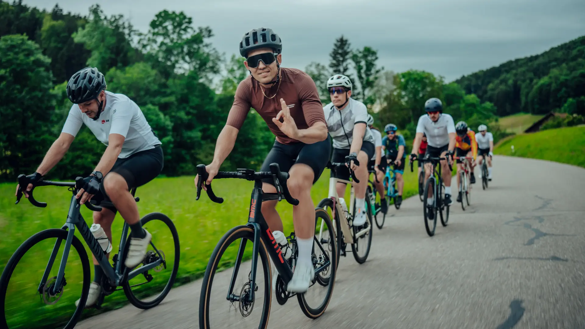 Group of Sauber Motorsport employees and cycling enthusiasts gathered for an industrial building for an afterwork cycling event.